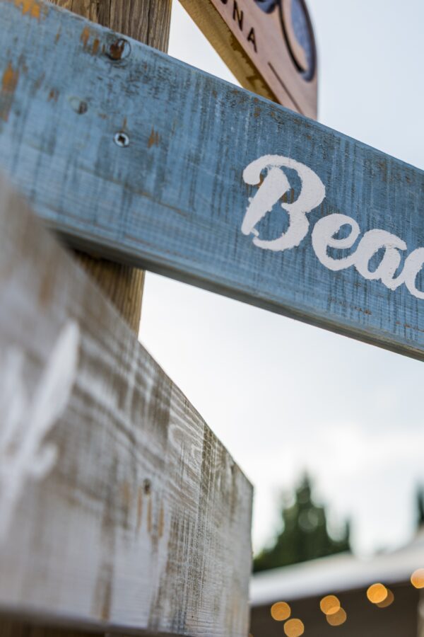 Selective focus shot of wooden beach signage with a blurred background